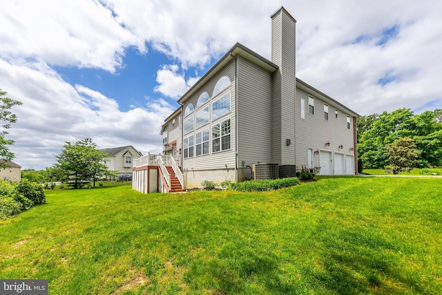 144 Cedar Ct, Woolwich Twp, NJ 08085 - back of house with stairway, a chimney, an attached garage, a yard, and a wooden deck