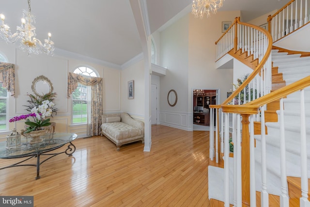 144 Cedar Ct, Woolwich Twp, NJ 08085 - living area with a chandelier, stairs, wood-type flooring, a decorative wall, and wainscoting