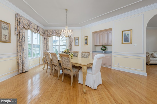 144 Cedar Ct, Woolwich Twp, NJ 08085 - dining space with a chandelier, arched walkways, light wood-style floors, a decorative wall, and crown molding