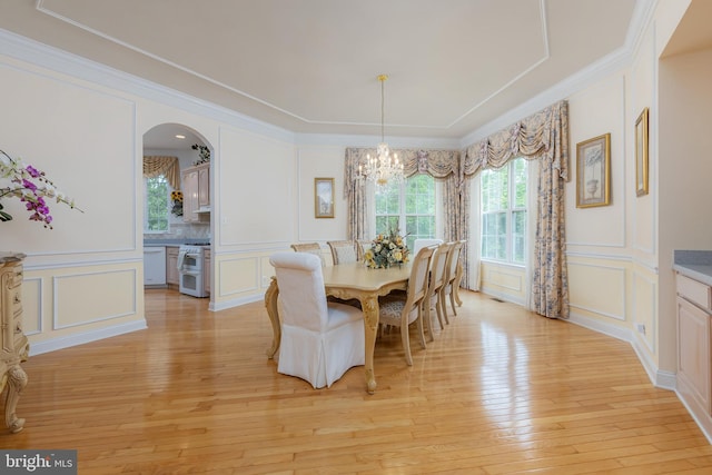 144 Cedar Ct, Woolwich Twp, NJ 08085 - dining space featuring a decorative wall, a chandelier, light wood-type flooring, arched walkways, and ornamental molding