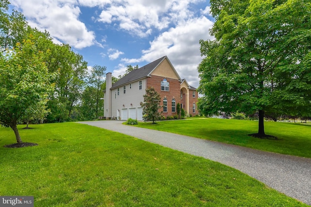 144 Cedar Ct, Woolwich Twp, NJ 08085 - view of property exterior with a garage, brick siding, a chimney, and a lawn