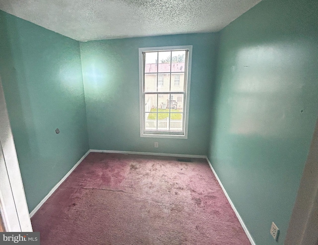 1222 N Calhoun St, Baltimore, MD 21217 - empty room featuring healthy amount of natural light, carpet flooring, a textured ceiling, and baseboards