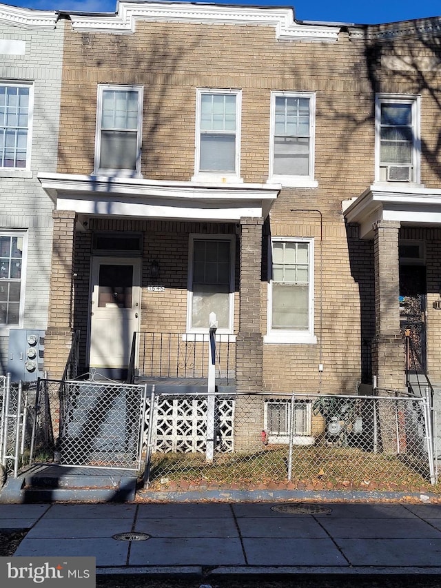 1646 Gales St NE, Washington, DC 20002 - townhome / multi-family property with brick siding, a fenced front yard, and covered porch