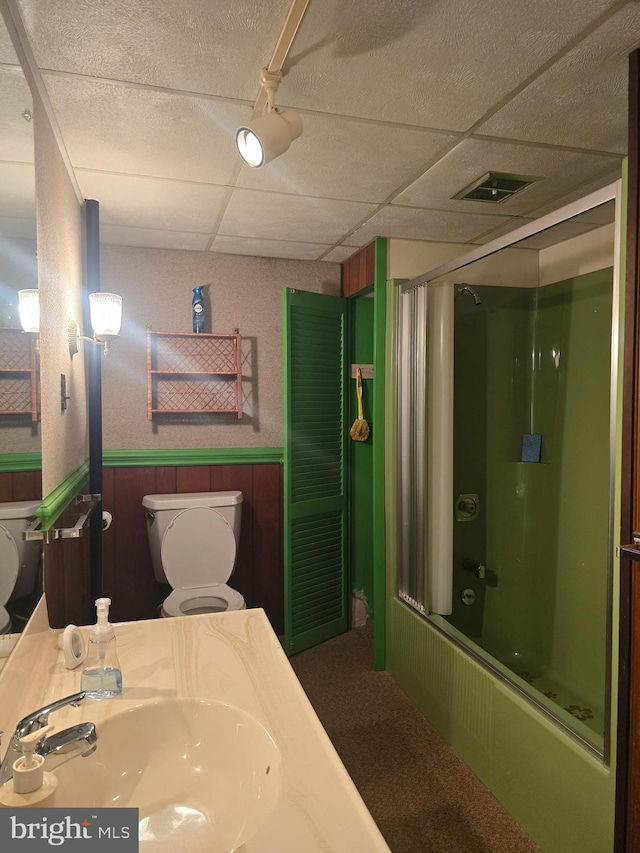 11 Maxwill Ln, Landisburg, PA 17040 - bathroom featuring a sink, toilet, a drop ceiling, a wainscoted wall, and combined bath / shower with glass door