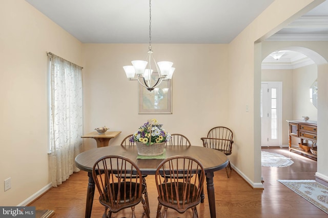 35206 Seagrass Plantation Ln, Dagsboro, DE 19939 - dining area with arched walkways, wood finished floors, a chandelier, baseboards, and ornamental molding