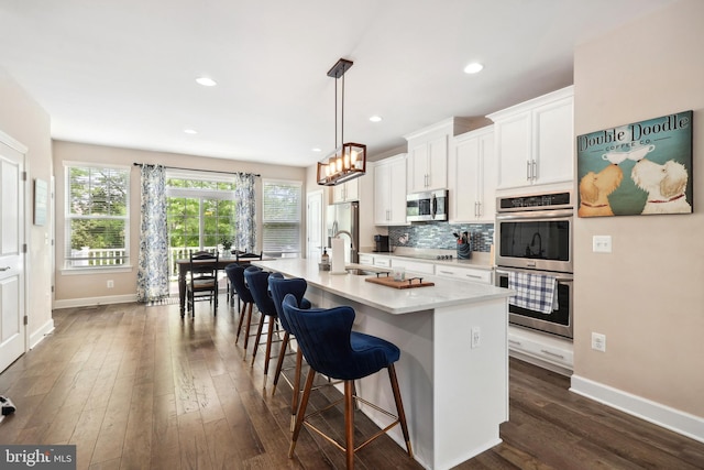 10744 Hinton Way, Manassas, VA 20112 - kitchen with stainless steel appliances, an island with sink, baseboards, a sink, and recessed lighting