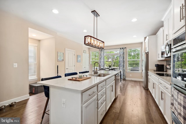 10744 Hinton Way, Manassas, VA 20112 - kitchen featuring a sink, appliances with stainless steel finishes, a breakfast bar area, a kitchen island with sink, and baseboards