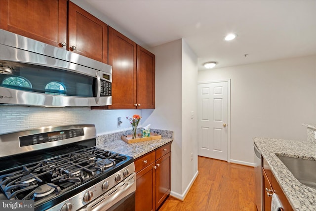 6124 Aster Haven Cir, Haymarket, VA 20169 - kitchen with appliances with stainless steel finishes, light wood finished floors, tasteful backsplash, light stone counters, and recessed lighting