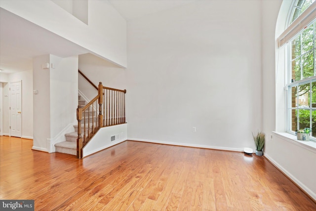 6124 Aster Haven Cir, Haymarket, VA 20169 - unfurnished living room featuring light wood-type flooring, stairway, and baseboards