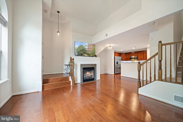 6124 Aster Haven Cir, Haymarket, VA 20169 - unfurnished living room featuring stairway, a fireplace with flush hearth, hardwood / wood-style flooring, baseboards, and recessed lighting