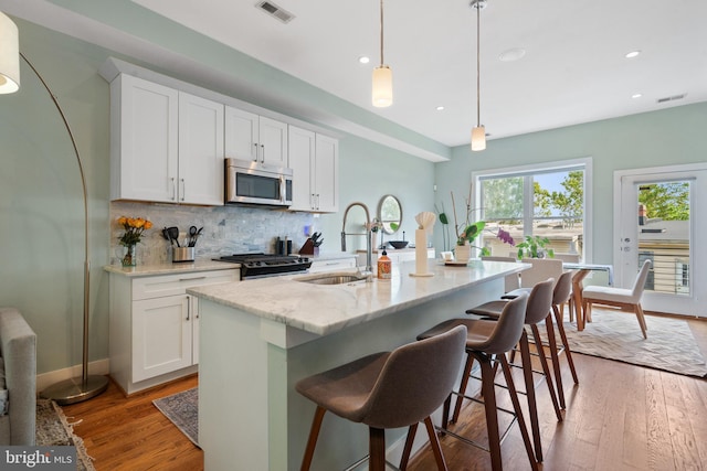 158 Bryant St NW Unit 2, Washington, DC 20001 - kitchen with stainless steel microwave, gas range, backsplash, a sink, and recessed lighting