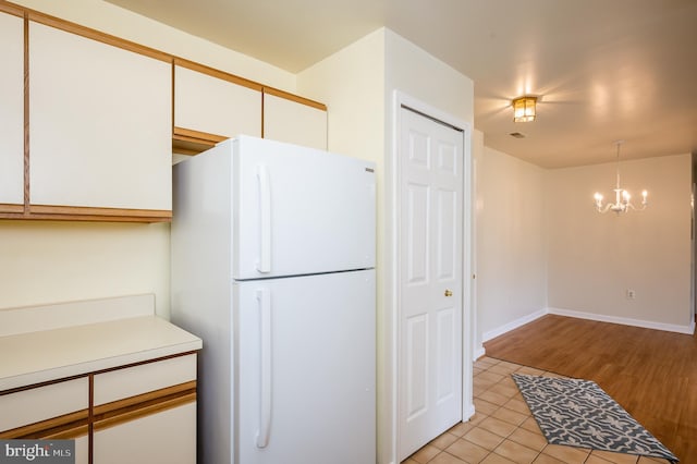 1310 Sheridan Pl Unit 108-17, Bel Air, MD 21015 - kitchen with freestanding refrigerator, a chandelier, white cabinets, light tile patterned floors, and light countertops