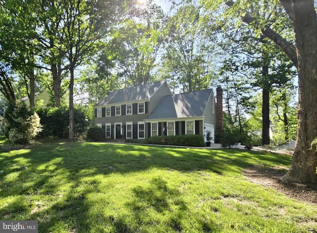 5068 Willow Oak Pl, Dumfries, VA 22025 - colonial inspired home with a front yard, a chimney, and a garage