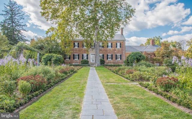 913A Caroline St, Fredericksburg, VA 22401 - view of front facade with a front yard, brick siding, and a chimney