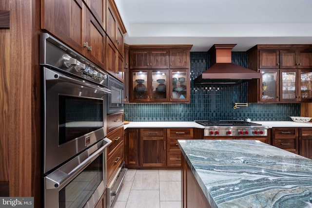 913A Caroline St, Fredericksburg, VA 22401 - kitchen with wall chimney exhaust hood, stainless steel appliances, decorative backsplash, and glass insert cabinets