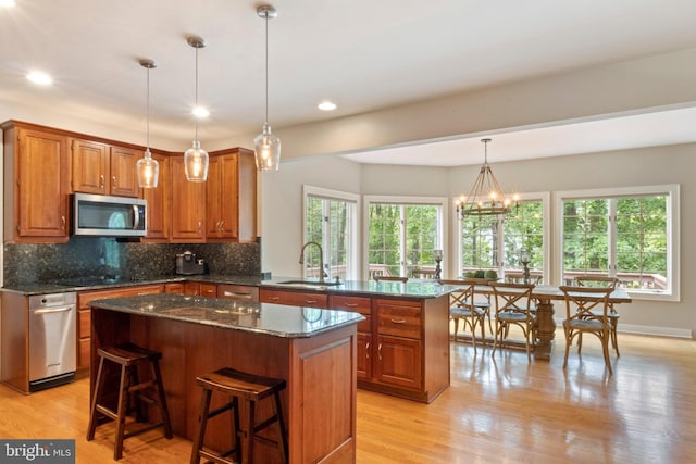 2 Turnberry Way, New Hope, PA 18938 - kitchen featuring stainless steel microwave, a sink, brown cabinets, tasteful backsplash, and a center island