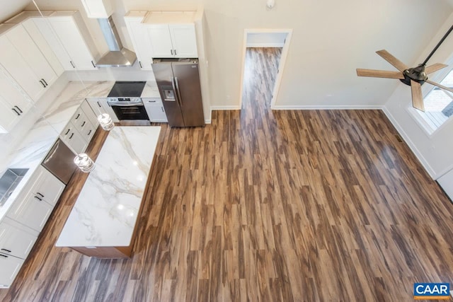 205 League Ln, Lovingston, VA 22949 - kitchen with stainless steel fridge, baseboards, wall chimney exhaust hood, dark wood-style flooring, and white cabinets