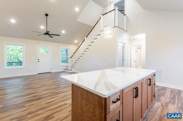 205 League Ln, Lovingston, VA 22949 - kitchen with a ceiling fan, brown cabinets, wood finished floors, light stone counters, and a kitchen island