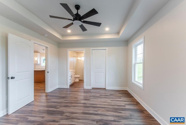205 League Ln, Lovingston, VA 22949 - unfurnished bedroom featuring a tray ceiling, baseboards, connected bathroom, dark wood finished floors, and a closet