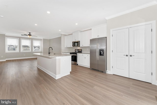 kitchen featuring stainless steel appliances, crown molding, a sink, ceiling fan, and white cabinets