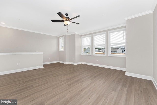 unfurnished room with baseboards, ceiling fan, wood finished floors, and crown molding
