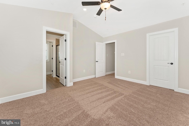 unfurnished bedroom featuring carpet, lofted ceiling, baseboards, and a ceiling fan