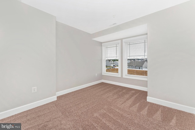 carpeted empty room with baseboards