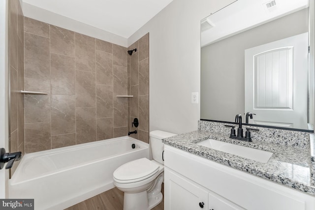 bathroom featuring toilet, bathtub / shower combination, vanity, and wood finished floors