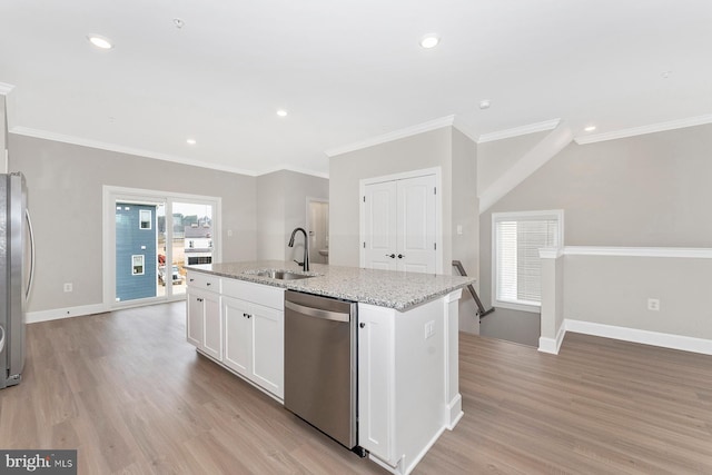 kitchen featuring appliances with stainless steel finishes, a sink, a kitchen island with sink, white cabinetry, and light wood-type flooring