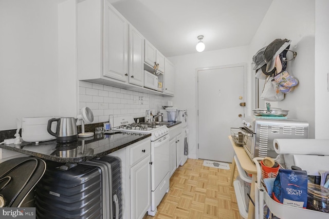 950 25th St NW Unit 301N, Washington, DC 20037 - kitchen with white gas stove, white cabinetry, decorative backsplash, dark countertops, and a sink