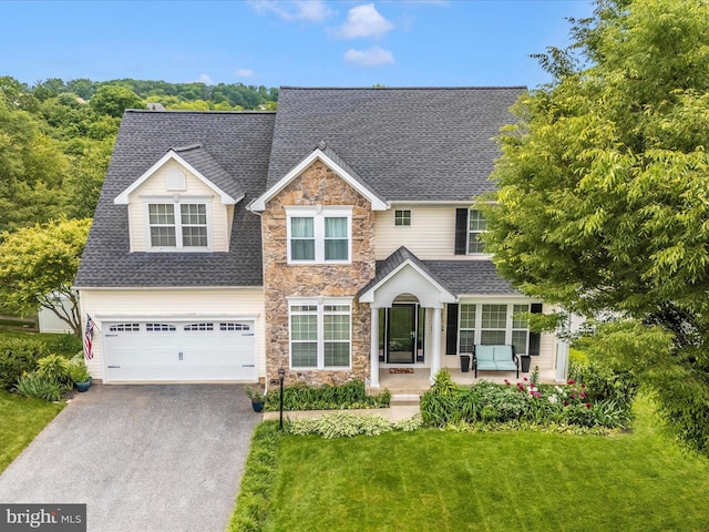 2619 Washington Way, Manchester, MD 21102 - traditional home with stone siding, driveway, roof with shingles, a front yard, and covered porch