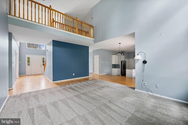 19 Pear Tree Pl, Sewell, NJ 08080 - unfurnished living room with a high ceiling, light colored carpet, baseboards, and light wood-type flooring