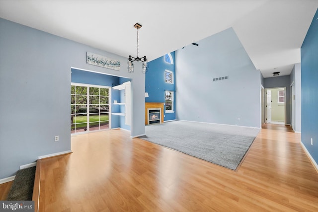19 Pear Tree Pl, Sewell, NJ 08080 - unfurnished living room featuring wood finished floors, a glass covered fireplace, baseboards, and a towering ceiling