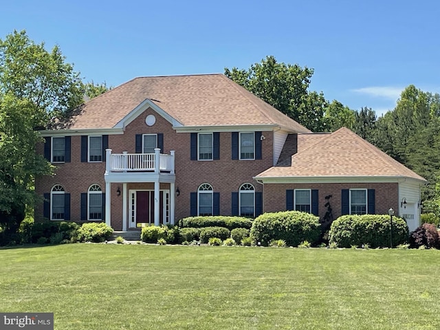 63 Lake Forest Dr, Mineral, VA 23117 - colonial-style house with brick siding, a front lawn, a balcony, and a shingled roof