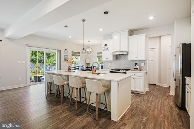 6023 Charles Henry Pl, Hanover, MD 21076 - kitchen featuring appliances with stainless steel finishes, under cabinet range hood, dark wood-style flooring, a center island with sink, and a sink