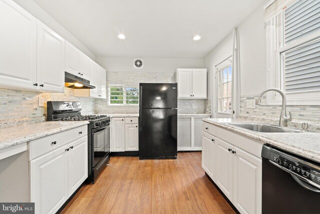 41 Bellevue Ter, Collingswood, NJ 08108 - kitchen featuring black appliances, under cabinet range hood, decorative backsplash, white cabinetry, and light wood-style floors