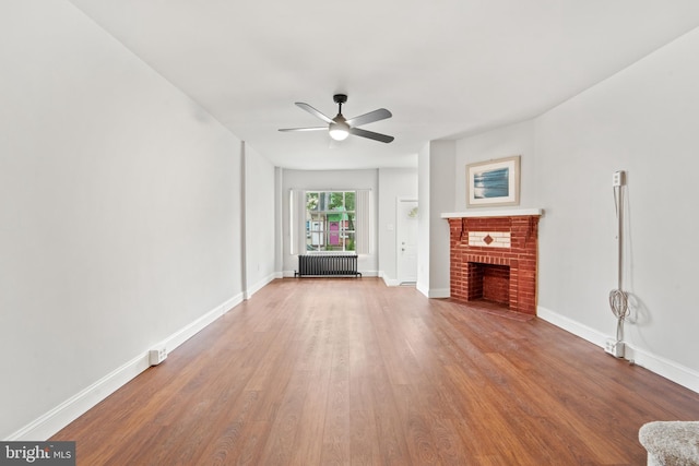 41 Bellevue Ter, Collingswood, NJ 08108 - unfurnished living room with radiator, wood finished floors, ceiling fan, and a brick fireplace