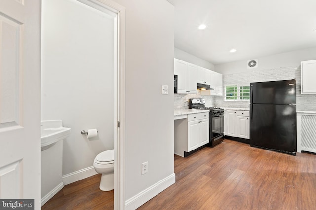41 Bellevue Ter, Collingswood, NJ 08108 - kitchen with black appliances, under cabinet range hood, wood finished floors, white cabinets, and recessed lighting