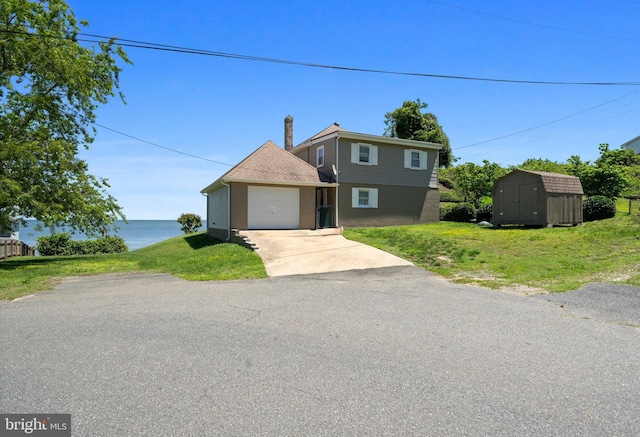 295 Chesapeake Ave, Prince Frederick, MD 20678 - view of front facade with driveway, an attached garage, a front lawn, and a water view
