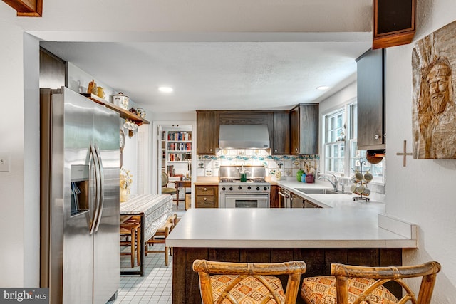 18919 Diary Rd, Montgomery Village, MD 20886 - kitchen featuring stainless steel appliances, wall chimney range hood, a sink, light countertops, and recessed lighting