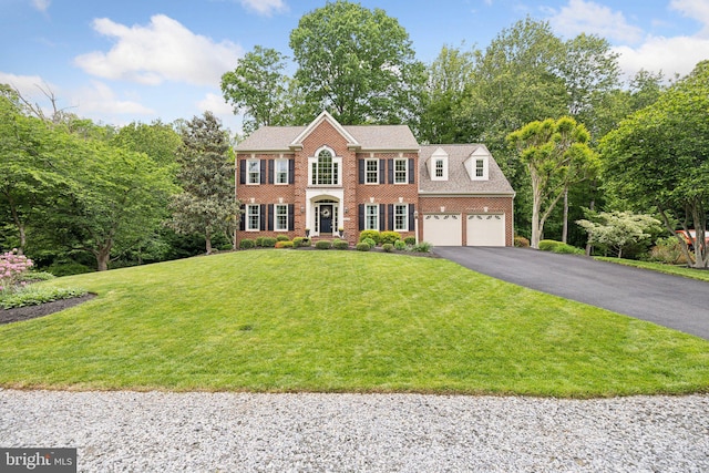 13016 Brookmead Dr, Manassas, VA 20112 - colonial inspired home featuring driveway, brick siding, a front yard, and view of scattered trees