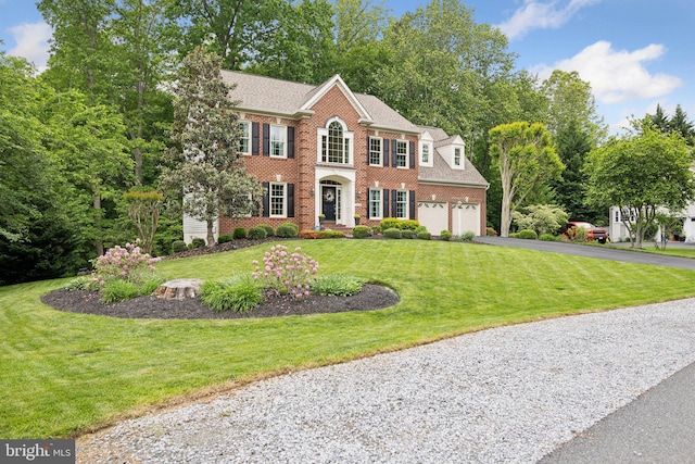13016 Brookmead Dr, Manassas, VA 20112 - colonial-style house with driveway, brick siding, a front yard, roof with shingles, and a garage