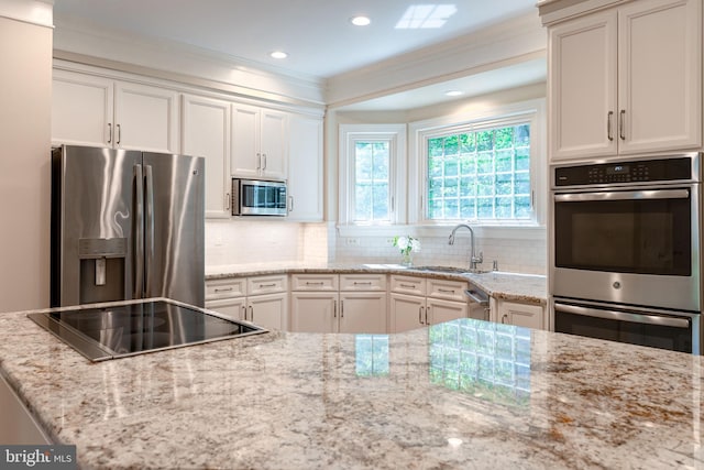 13016 Brookmead Dr, Manassas, VA 20112 - kitchen featuring appliances with stainless steel finishes, crown molding, a sink, light stone countertops, and tasteful backsplash
