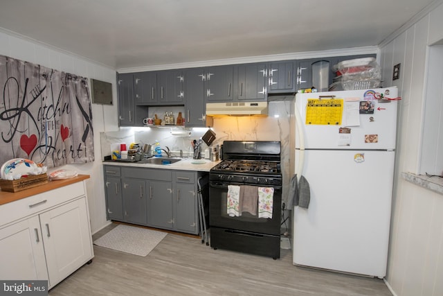 3444 G St, Philadelphia, PA 19134 - kitchen featuring freestanding refrigerator, black range with gas stovetop, under cabinet range hood, decorative backsplash, and light wood-type flooring