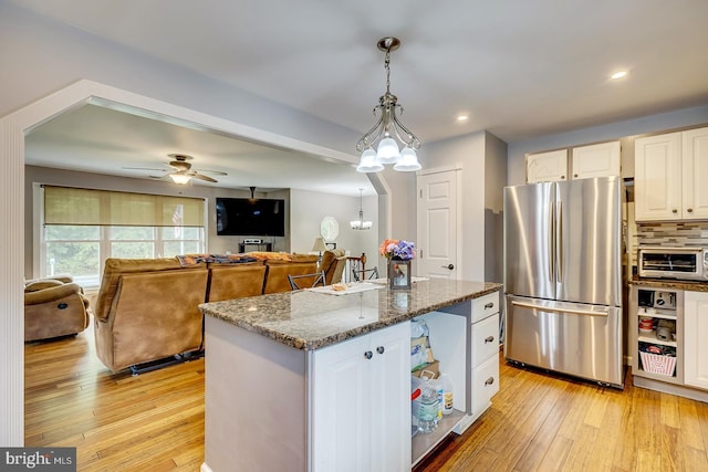 14298 S Union Church Rd, Ellendale, DE 19941 - kitchen with freestanding refrigerator, dark stone countertops, white cabinetry, light wood-style flooring, and recessed lighting