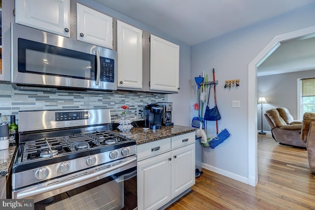 14298 S Union Church Rd, Ellendale, DE 19941 - kitchen featuring appliances with stainless steel finishes, light wood-style flooring, backsplash, white cabinets, and baseboards