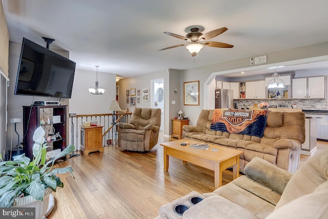 14298 S Union Church Rd, Ellendale, DE 19941 - living room featuring a chandelier, ceiling fan, light wood-style flooring, and baseboards