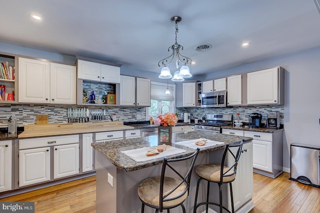 14298 S Union Church Rd, Ellendale, DE 19941 - kitchen featuring appliances with stainless steel finishes, open shelves, backsplash, pendant lighting, and a kitchen breakfast bar