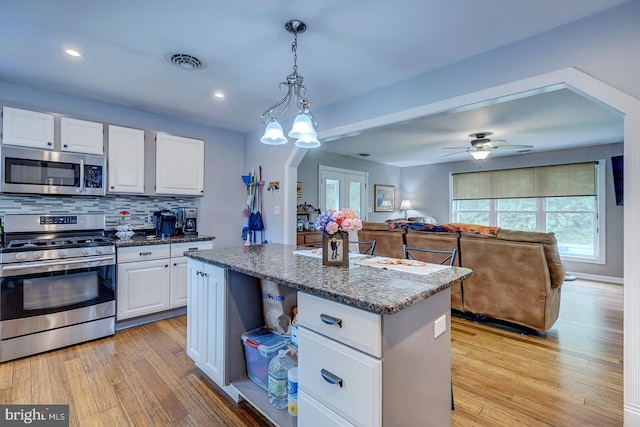 14298 S Union Church Rd, Ellendale, DE 19941 - kitchen featuring stainless steel appliances, white cabinets, light wood-style flooring, open floor plan, and backsplash
