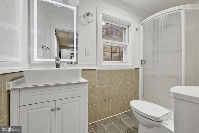 406 S Eaton St, Baltimore, MD 21224 - bathroom with toilet, tile walls, vanity, a shower stall, and ornamental molding